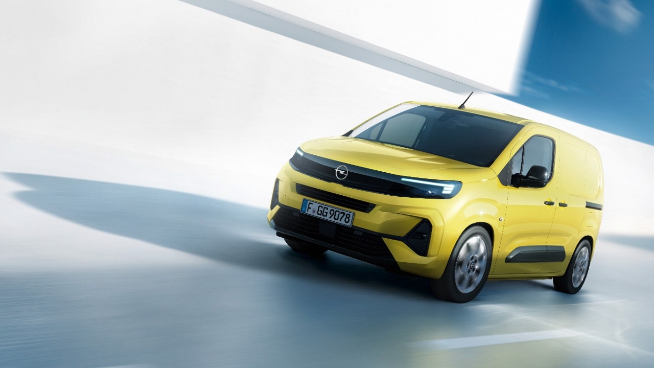 Pogled s sprednje strani rumenega novega Opel Comba Van v gibanju